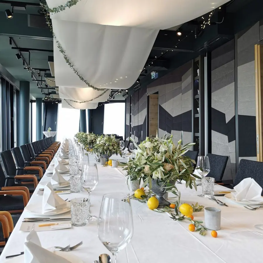 Festlich gedeckte Tafel mit heller Tischdekoration in einer Eventlocation